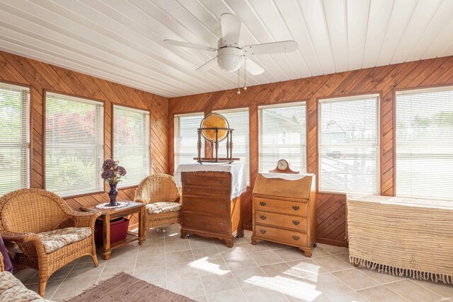sunroom / solarium with healthy amount of natural light, tile patterned floors, wooden walls, and wooden ceiling