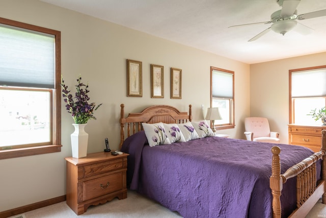 bedroom with light colored carpet, baseboards, and a ceiling fan