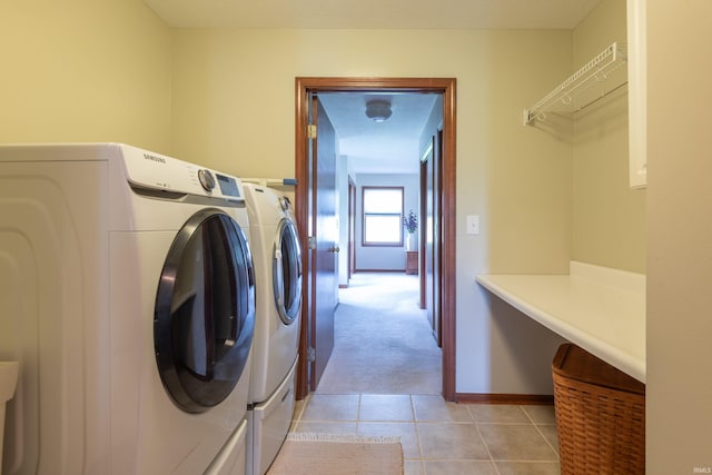 washroom with washer and dryer, light tile patterned flooring, light colored carpet, and baseboards