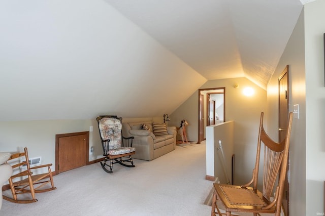 living area with light colored carpet, lofted ceiling, and baseboards