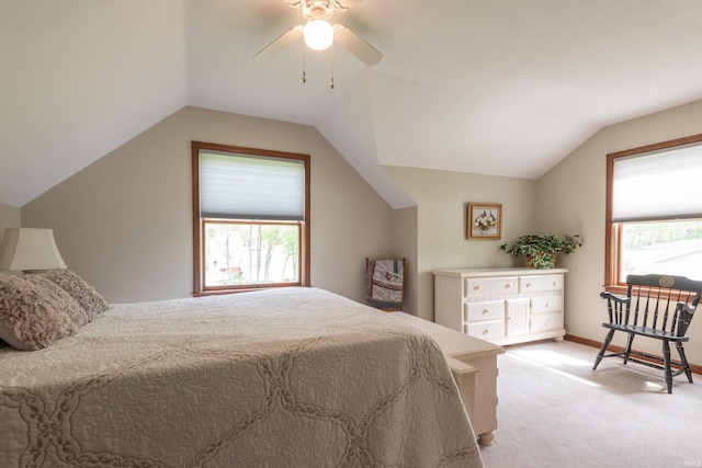 bedroom featuring light colored carpet, multiple windows, vaulted ceiling, a ceiling fan, and baseboards