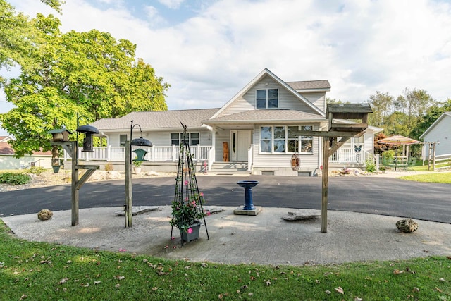 view of front of house featuring a shingled roof and covered porch