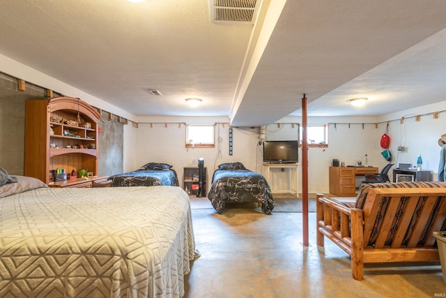 bedroom with concrete flooring and a textured ceiling