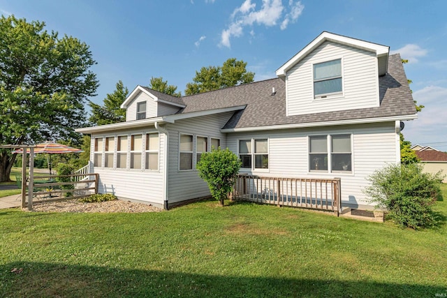 view of front of house with a shingled roof and a front lawn