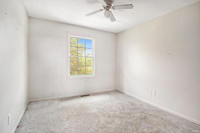 empty room featuring carpet floors, a ceiling fan, and baseboards