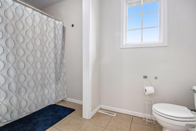 full bathroom featuring toilet, tile patterned floors, baseboards, and curtained shower