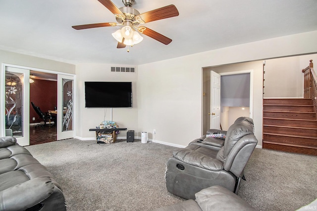carpeted living area with stairs, baseboards, and ceiling fan