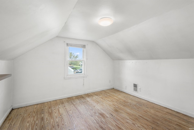 bonus room featuring wood finished floors, vaulted ceiling, and baseboards