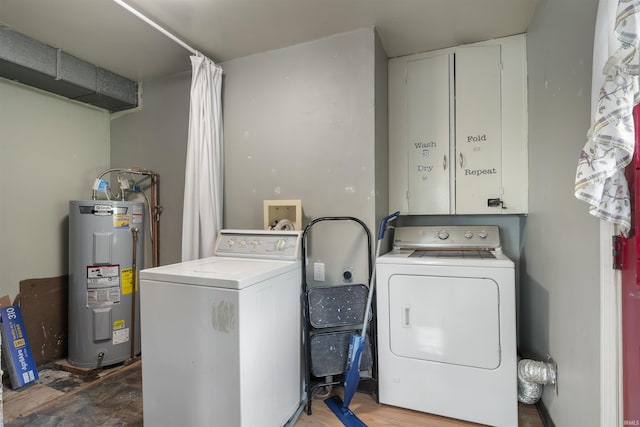 washroom with water heater, cabinet space, and independent washer and dryer