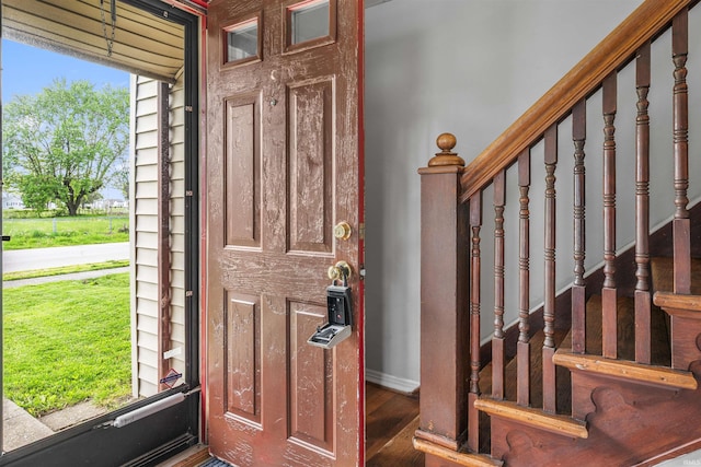 entryway with baseboards, stairs, and wood finished floors