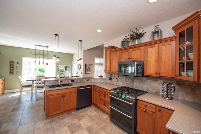 kitchen with a sink, range with two ovens, dishwasher, a peninsula, and brown cabinetry