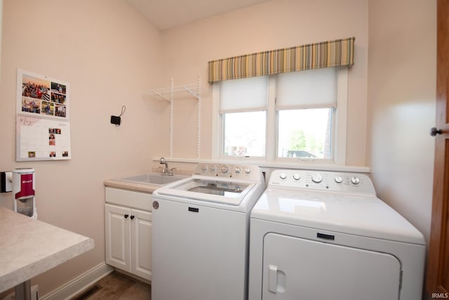 laundry area featuring separate washer and dryer, cabinet space, and baseboards