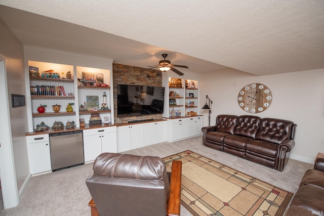 living area with light carpet, a ceiling fan, a textured ceiling, bar, and baseboards