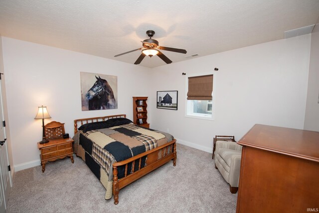bedroom featuring light colored carpet, baseboards, and a ceiling fan