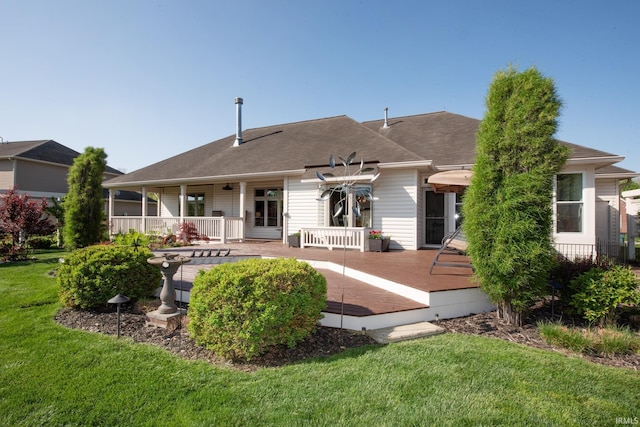 back of house with a lawn and a shingled roof