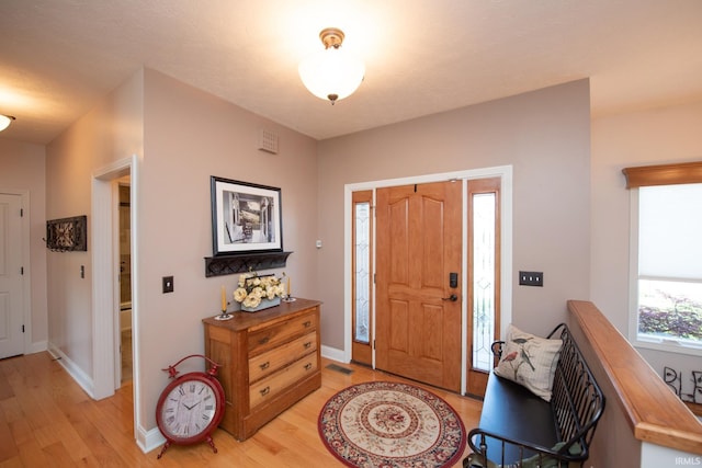 entryway with light wood finished floors and baseboards