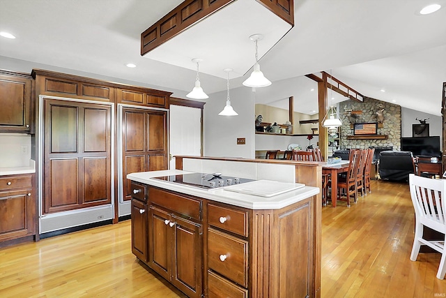 5571 Poff Rd, Martinsville, IN 46151 - kitchen featuring black electric cooktop, light wood-style floors, lofted ceiling, light countertops, and a kitchen island