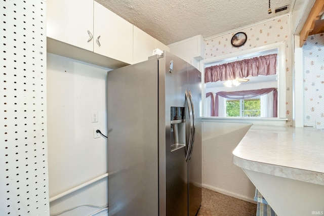 kitchen featuring stainless steel refrigerator with ice dispenser, white cabinetry, and a textured ceiling