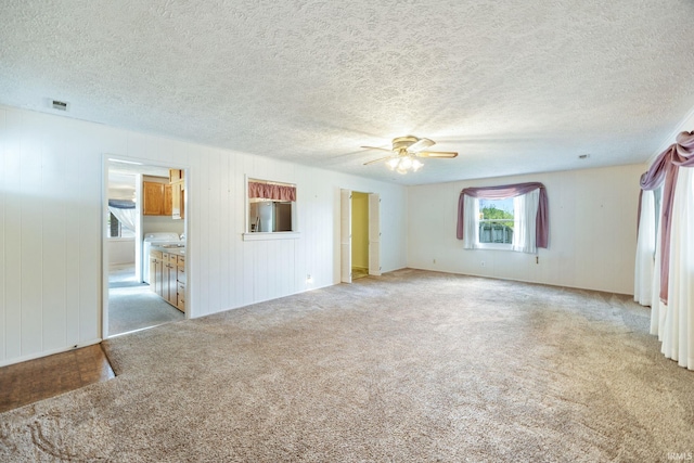 unfurnished living room with carpet floors, ceiling fan, and a textured ceiling