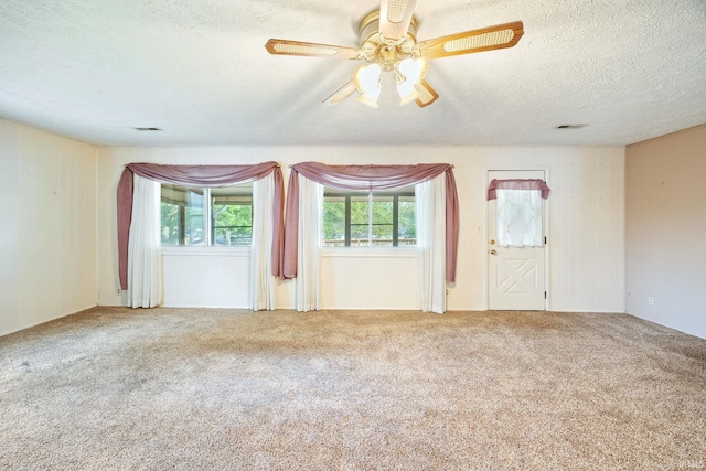 carpeted empty room with a textured ceiling and ceiling fan