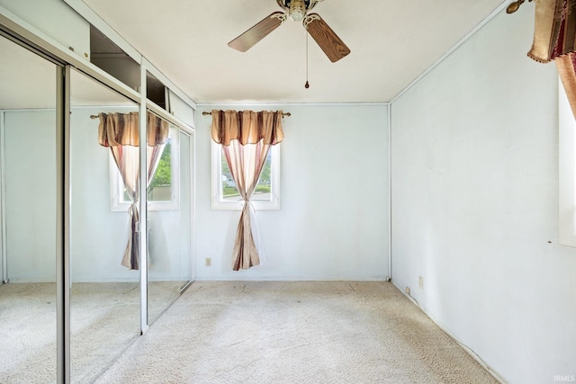 unfurnished bedroom featuring carpet, a closet, and a ceiling fan