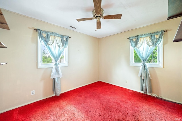 spare room with healthy amount of natural light, carpet flooring, ceiling fan, and baseboards