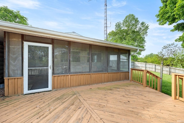 wooden terrace featuring a sunroom and fence