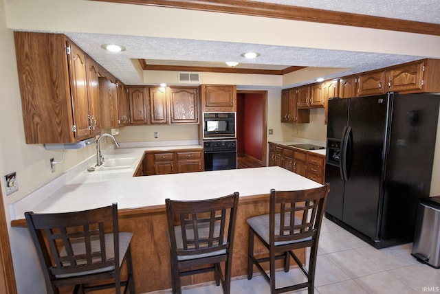3010 Cypress Ct, Evansville, IN 47711 - kitchen with black appliances, a sink, a raised ceiling, a peninsula, and light countertops