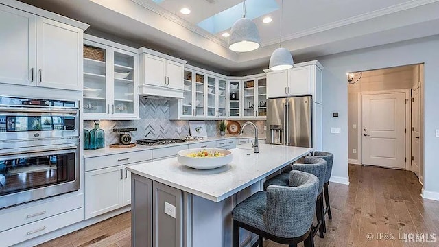 571 Tamarind Dr, West Lafayette, IN 47906 - kitchen featuring appliances with stainless steel finishes, crown molding, light countertops, a sink, and wood finished floors