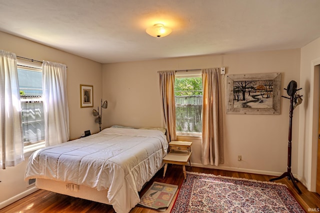 bedroom with wood finished floors and baseboards