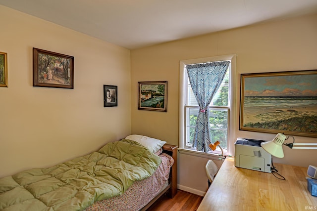 bedroom featuring wood finished floors and baseboards