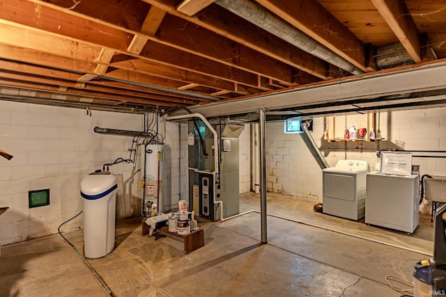 unfinished basement featuring gas water heater, washing machine and dryer, a water softener system, and heating unit