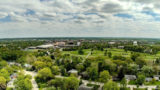 aerial view of residential area with a golf club and a tree filled landscape