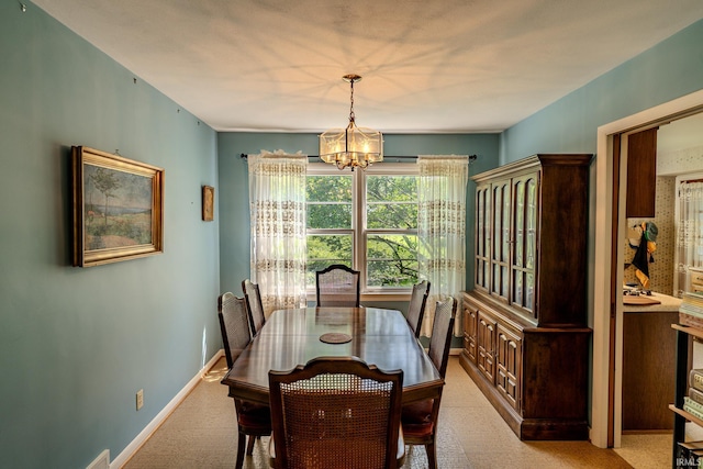 dining room featuring a chandelier, baseboards, and carpet