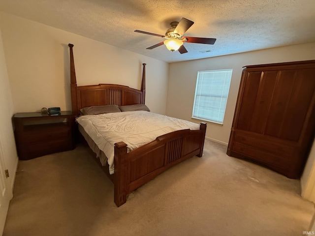 bedroom with light carpet, a textured ceiling, and a ceiling fan