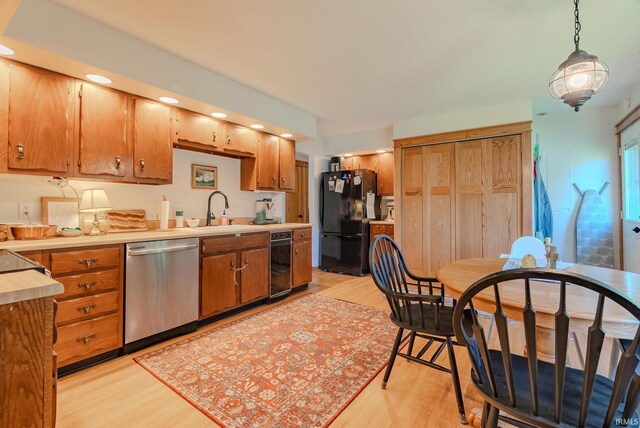 1918 Mckibben St, Wabash, IN 46992 - kitchen with stainless steel dishwasher, freestanding refrigerator, a sink, light wood-style floors, and light countertops