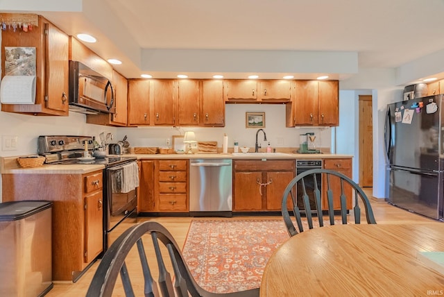 1918 Mckibben St, Wabash, IN 46992 - kitchen featuring black appliances, a sink, light countertops, light wood-type flooring, and brown cabinets