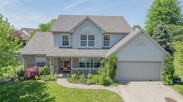 traditional-style home with a porch, driveway, a front yard, roof with shingles, and brick siding