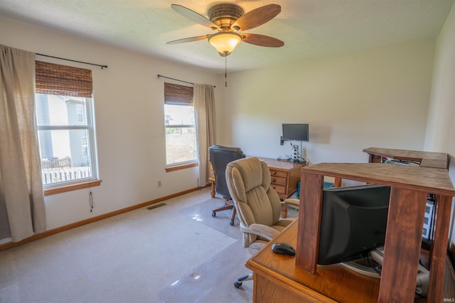office space featuring carpet, baseboards, a ceiling fan, and a textured ceiling