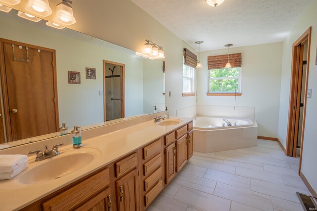 full bathroom with a garden tub, double vanity, a shower with shower door, and a textured ceiling