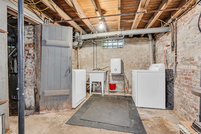 below grade area with washing machine and clothes dryer and a sink