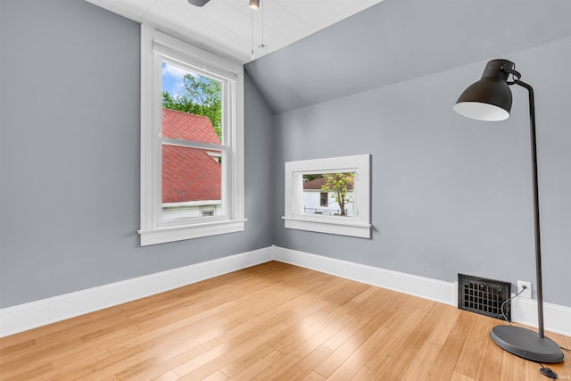 additional living space featuring wood finished floors, ceiling fan, baseboards, and vaulted ceiling