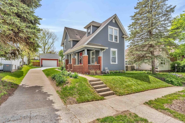 view of front of house featuring a detached garage, an outbuilding, a front lawn, a shingled roof, and brick siding
