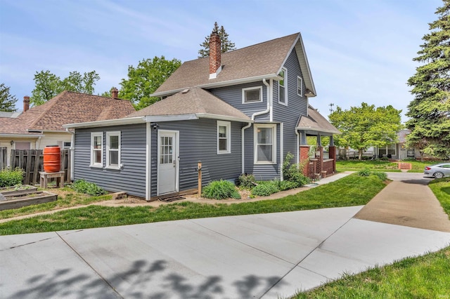 view of front of house with a chimney and a front lawn