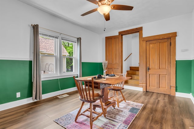 dining room featuring wood finished floors, ceiling fan, stairway, and baseboards
