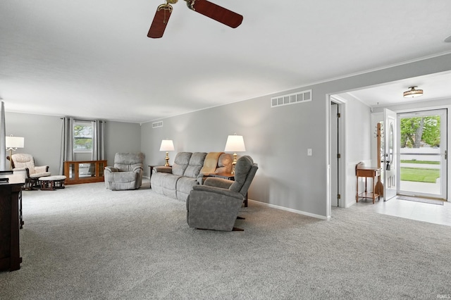 carpeted living area featuring ceiling fan and baseboards