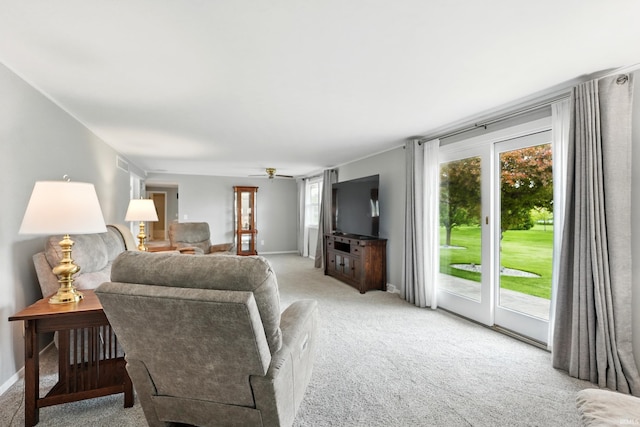 living area featuring light carpet, plenty of natural light, and baseboards