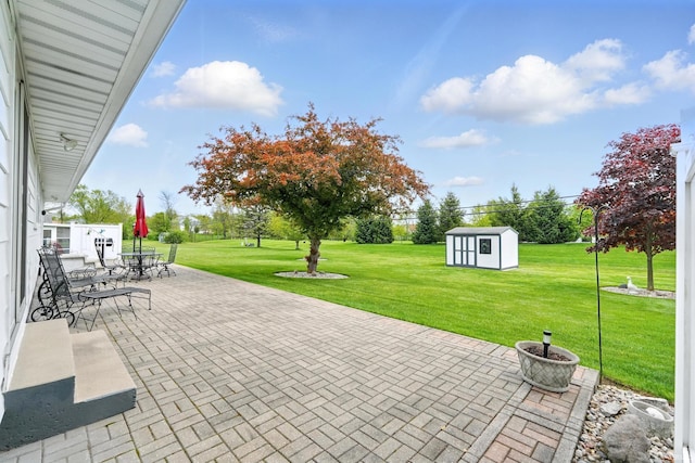 view of patio with a storage shed, an outdoor structure, and outdoor dining space