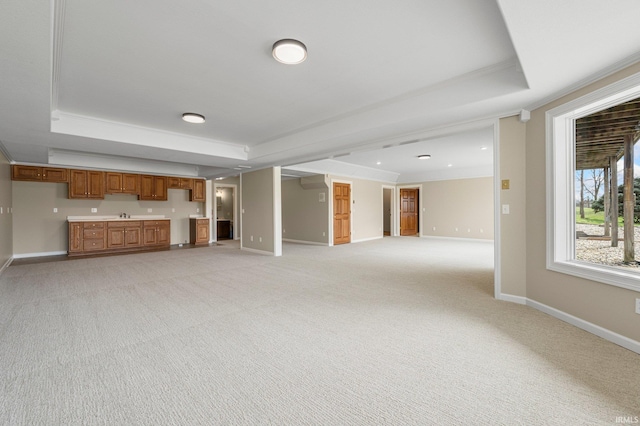 5006 Vandolah Rd, Leo, IN 46765 - unfurnished living room featuring a tray ceiling, baseboards, light carpet, a sink, and crown molding