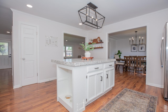 4100 Triple Crown Dr, Newburgh, IN 47630 - kitchen with a chandelier, white cabinetry, light wood-style flooring, crown molding, and a kitchen island